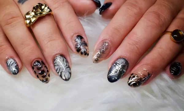 Unhas com estampa de oncinha e folhas sobre pelúcia branca